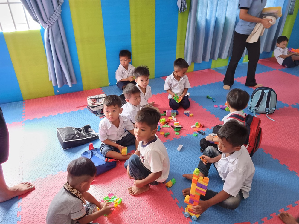 Eine Gruppe von Jungen beim Spielen auf dem kindgerechten und weichen Boden des Kindergartens.
