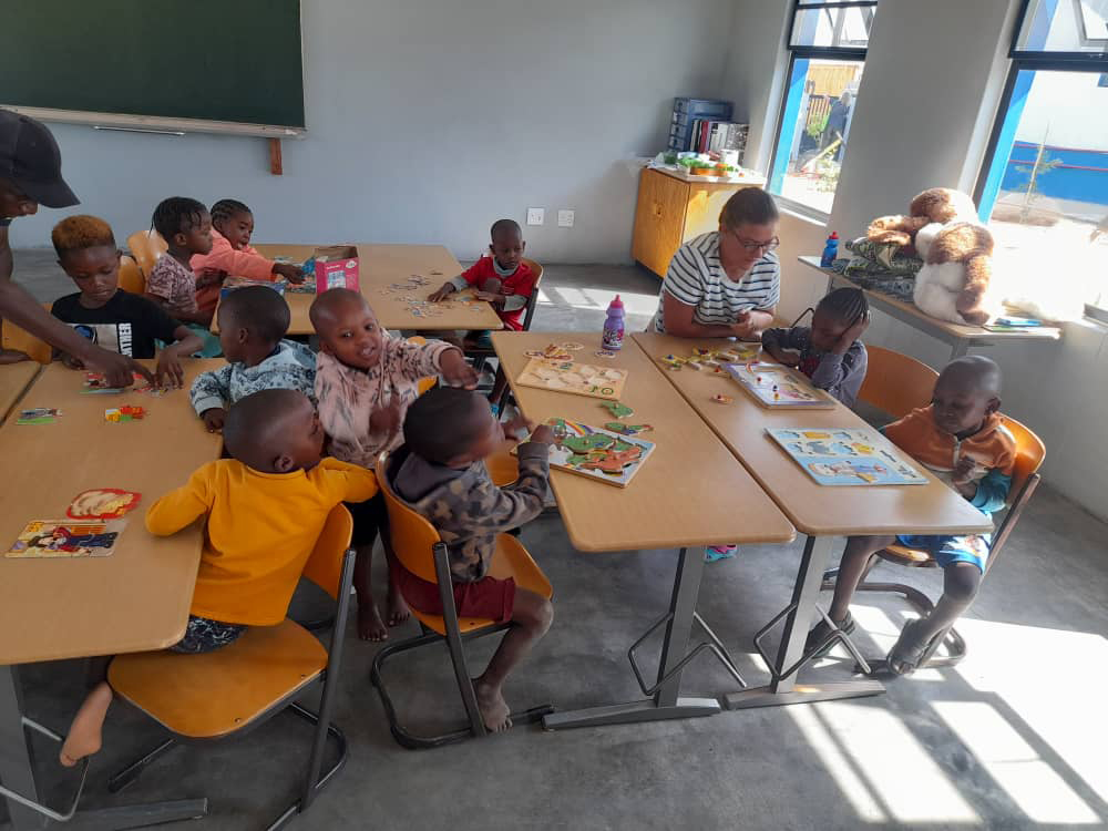 Die Kindergartenkinder beim Spielen mit einer Volontärin